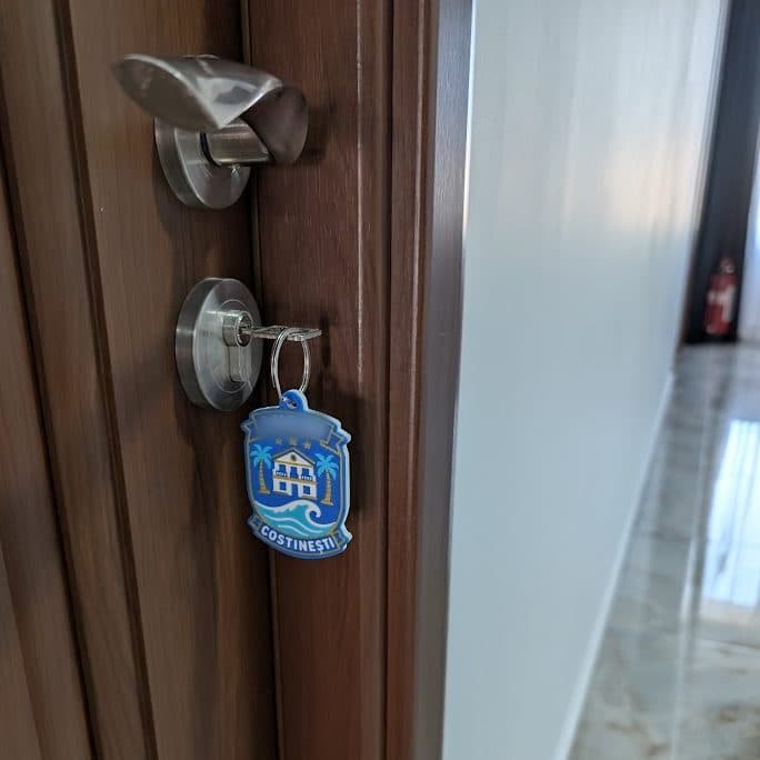 A room door with the key in the lock and the tag on its ring